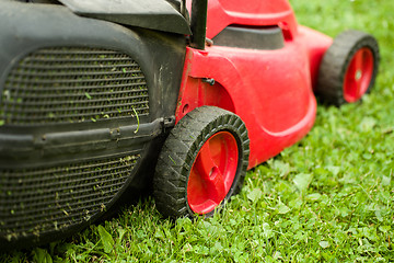 Image showing red lawnmower on green grass