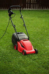 Image showing red lawnmower on green grass