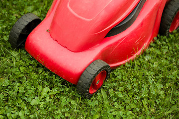 Image showing red lawnmower on green grass