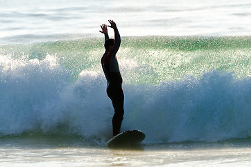 Image showing Long boarder surfing the waves at sunset