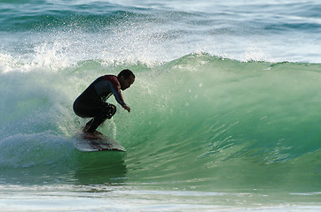 Image showing Long boarder surfing the waves at sunset