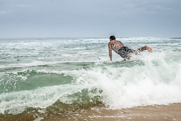 Image showing Surfer entering the water