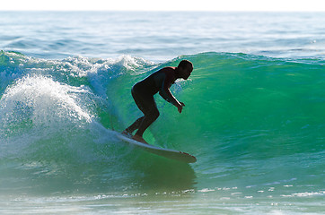 Image showing Long boarder surfing the waves at sunset