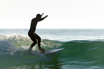 Image showing Long boarder surfing the waves at sunset