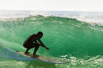 Image showing Long boarder surfing the waves at sunset