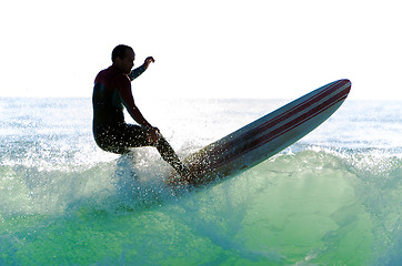 Image showing Long boarder surfing the waves at sunset