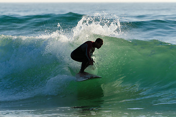 Image showing Long boarder surfing the waves at sunset