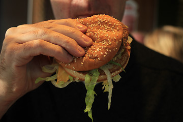 Image showing Man holding a hamburger