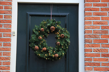 Image showing Classic christmas wreath with decorations on a door