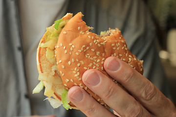 Image showing Man holding a hamburger