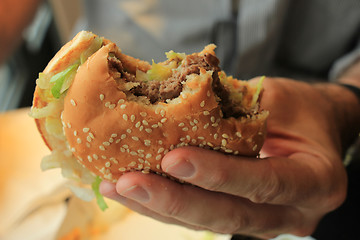 Image showing Man holding a hamburger