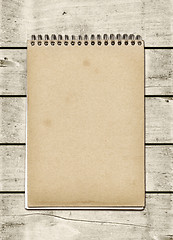 Image showing Closed spiral Note book on a white wood table