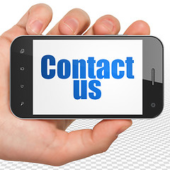 Image showing Advertising concept: Hand Holding Smartphone with Contact Us on display