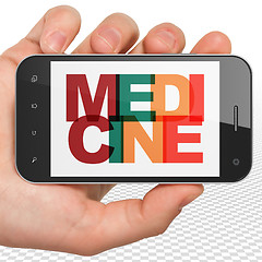 Image showing Health concept: Hand Holding Smartphone with Medicine on  display
