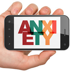 Image showing Medicine concept: Hand Holding Smartphone with Anxiety on  display