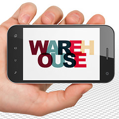 Image showing Industry concept: Hand Holding Smartphone with Warehouse on  display