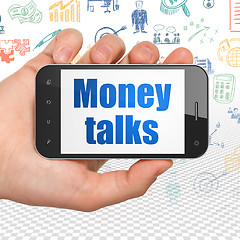 Image showing Finance concept: Hand Holding Smartphone with Money Talks on display