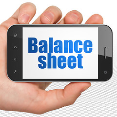 Image showing Banking concept: Hand Holding Smartphone with Balance Sheet on display