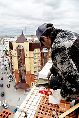 Image showing Tyumen, Russia - May 23, 2008: Construction of 18 floor brick residental house at intersection of streets of Gercena and Chelyuskincev. Bricklayer behind work. It is demolished because of bad base