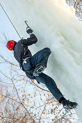 Image showing Man climbs upward on ice climbing competition