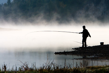 Image showing Man fishing at river shore 