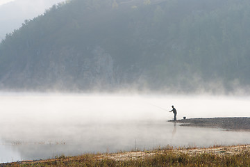 Image showing Man fishing at river shore 