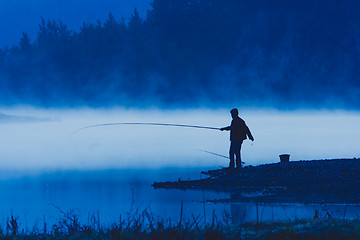 Image showing Man fishing at river shore 