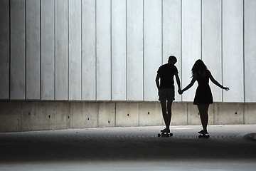 Image showing Young pair in love of stylish teenagers ride longboards 