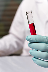 Image showing Closeup chemist with red liquid