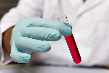 Image showing Closeup chemist with red liquid