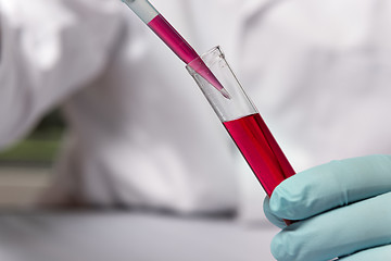 Image showing Closeup chemist with red liquid