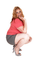 Image showing Plus size woman crouching in shorts and heels.