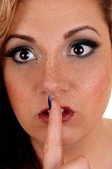Image showing Woman\'s face with one finger over mouth.