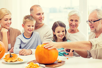 Image showing happy family sitting with pumpkins at home