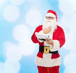 Image showing man in costume of santa claus with notepad