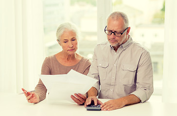 Image showing senior couple with papers and calculator at home