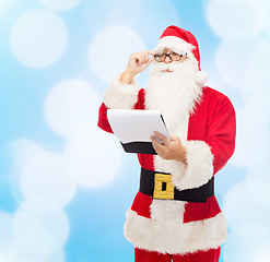 Image showing man in costume of santa claus with notepad