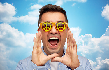 Image showing face of shouting man in green peace sunglasses