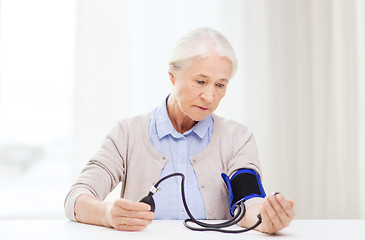 Image showing old woman with tonometer checking blood pressure