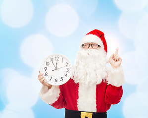 Image showing man in costume of santa claus with clock