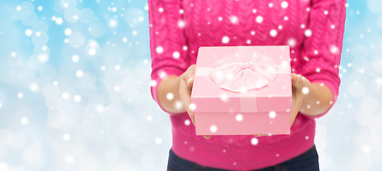 Image showing close up of woman in pink sweater holding gift box