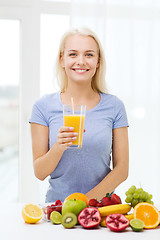 Image showing smiling woman drinking fruit juice at home