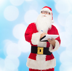 Image showing man in costume of santa claus with notepad