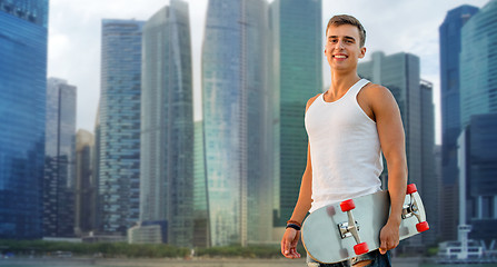 Image showing smiling man with skateboard over singapore city