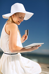 Image showing woman in hat doing online shopping outdoors
