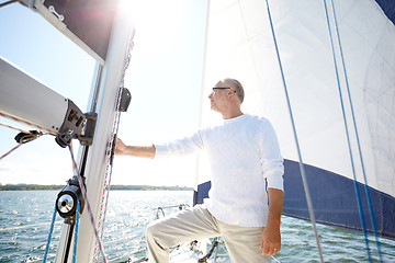 Image showing senior man on sail boat or yacht sailing in sea