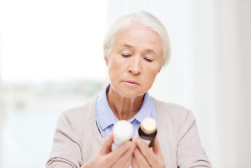 Image showing senior woman with medicine jars at home