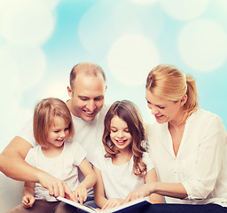 Image showing happy family with book at home