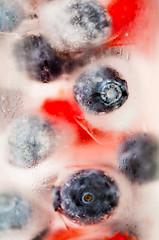 Image showing close up of fruit water with ice cubes over glass