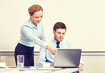 Image showing businessman and secretary with laptop in office